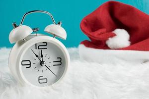 Kerstdag thema decoratie met hoed santa en witte retro clock.copy ruimte voor text.celebration kerst en x'mas concept.on groene achtergrond foto