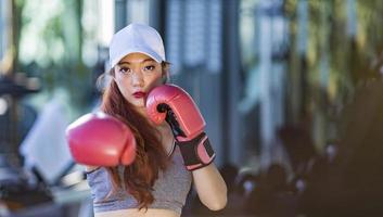 aziatische vrouw heeft boksoefening in de sportschool voor fitness en een gezonde levensstijl met kopieerruimte foto