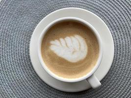 cappuccino plat gelegd. koffie witte kop - bovenaanzicht. koffieschuim met patroon foto