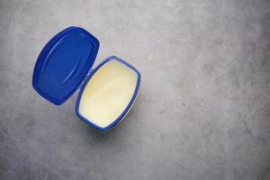 bovenaanzicht van vaseline in een container op zwarte achtergrond foto