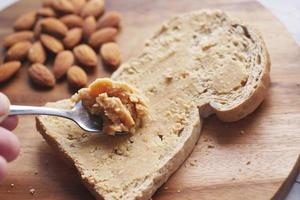 amandelboter op een bruin brood op tafel foto