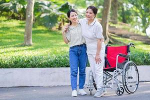 jonge Aziatische dochter die voor haar gehandicapte moeder zorgt foto