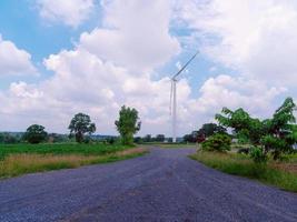 rotsachtige weg naar windturbine met bewolkte blauwe lucht in de stad foto