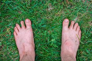 man staat blootsvoets op vers groen gras foto