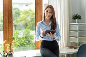 creatieve aziatische jonge vrouw die aan tablet in haar studio werkt. foto