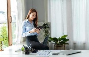 creatieve aziatische jonge vrouw die aan tablet in haar studio werkt. foto