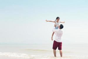 gelukkige familie op strand rennen en springen bij zonsondergang foto