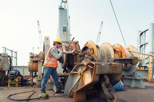 voorman die walkie-talkie en veiligheidshelm gebruikt om in vrachtschip te werken foto