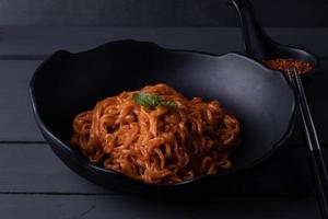 Koreaanse pittige instant noedels in zwarte kom foto