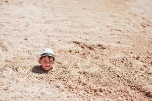 jonge jongen hoofd op zand dragen panama hoed. grappige zomervakantie. foto