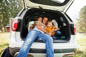 familie bij voertuiginterieur. vader met zijn zonen. kinderen in de kofferbak. reizen met de auto in de bergen, sfeerconcept. foto