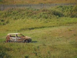 verlaten verroeste auto in een landelijk veld foto