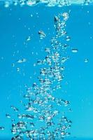 abstracte achtergrondafbeelding van bellen in water. schoon water met waterdruppels en golven. zoet water een glas met bubbels blauwe achtergrond. foto