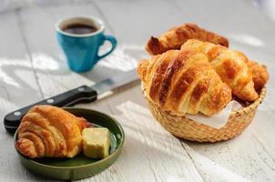 ontbijt met vers gebakken croissants, boter en koffie