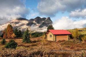 houten hutten met rotsachtige bergen in het herfstbos in het provinciale park van Assiniboine foto