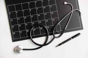 stethoscoop met kalender, medische afspraakherinnering en jaarlijks controleconcept, bovenaanzicht foto