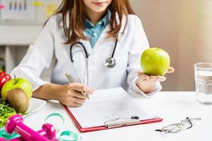 voedingsdeskundige die patiënt overleg geeft met gezond fruit en groente, juiste voeding en dieetconcept foto