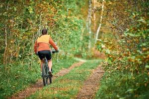 vrouwelijke mountainbiker rijden op de fiets in de natuur deelnemen aan competitie, sport, fitness, gezondheid foto