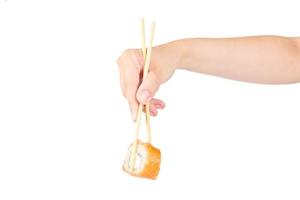 vrouwelijke hand met philadelphia maki roll met bamboe eetstokjes geïsoleerd op een witte achtergrond foto