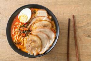 ramen noodles pittige tomyum soep met geroosterd varkensvlees foto