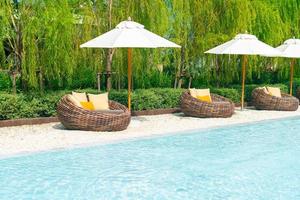 terrasstoel met kussen en parasol rond zwembad foto