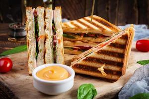 clubsandwich met ham, tomaat, kaas en spinazie. gegrilde panini foto