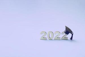 afstuderen 2022 met afgestudeerde hoed op houten nummer 2022 op zeer peri tredy kleurenachtergrond, klasse van 2022 foto