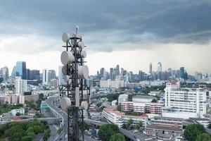 telecommunicatietoren met 5g cellulaire netwerkantenne op stadsachtergrond foto