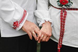 close-up van senior man en vrouw hand in hand en buiten wandelen. achteraanzicht van oud paar dat hand in hand buiten loopt. het oude paar houdt elkaars hand vast. foto