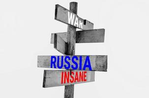 houten verkeersbord met woorden oorlog, rusland, krankzinnig, sancties, agressie, regressie foto