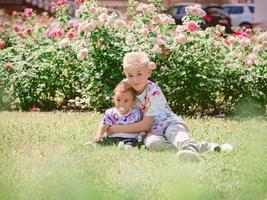 kaukasische schattige schattige jongens broers en zussen houden elkaar in zonnige dag buiten. familie, hulp, ondersteuningsconcept foto
