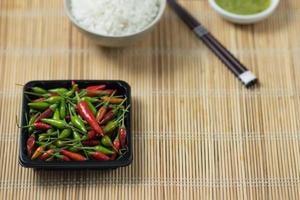 groene en rode pepers geplaatst op een houten tafel foto