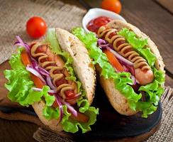 hotdog met ketchupmosterd en sla op houten achtergrond. foto