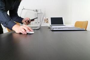 zakenman of ontwerper met behulp van muis en smartphone met laptop en digitale tabletcomputer in modern kantoor foto
