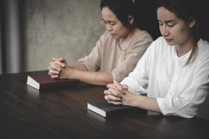 twee vrouwen leggen de handen op de bijbel en bidden tot god. concept van het christendom. .geloof in het leven. bidden voor anderen. de kracht van hoop of liefde en loyaliteit. foto