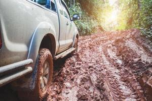 vuile offroad-auto, suv bedekt met modder op plattelandsweg, offroad-banden, offroad-reizen en rijconcept. foto