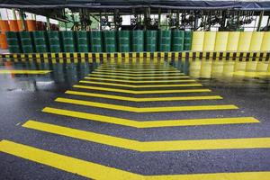 olievaten groen of chemische vaten verticaal gestapeld op het lijnsymbool van de industrieweg. foto