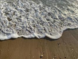 bovenaanzicht van het zandstrand en de golven foto