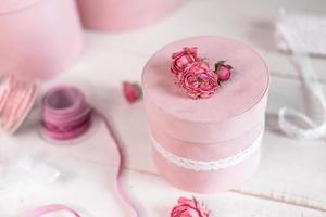 mooie roze ronde cadeauverpakking is versierd met versmalde rozen. romantisch verpakkingsconcept foto