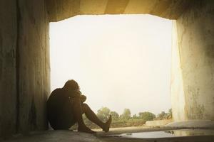 Azië jij man zit alleen.hij zit onder grote tunnel.man erg verdrietig en depressief.verdrietig,alleen,zelfmoord.wanhoop. ziekte.photo gezondheid en teleurstelling concept. foto