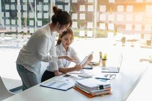 marketing, financieel, boekhouding, planning, team van zakenvrouwen analyseren bedrijfsresultaten en winst met grafiekstatistieken. gebruik een laptop en een rekenmachine om het saldo van het bedrijf te berekenen. foto