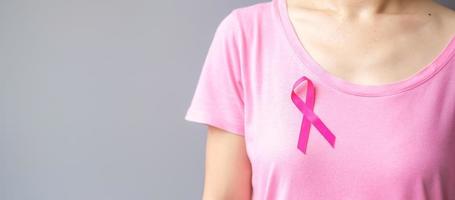 oktober borstkanker bewustzijnsmaand, oudere vrouw in roze t-shirt met roze lint voor het ondersteunen van mensen die leven en ziek zijn. internationaal vrouwen-, moeder- en wereldkankerdagconcept foto