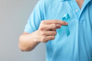 november prostaatkanker bewustzijnsmaand, man in blauw shirt met hand met blauw lint voor het ondersteunen van mensen die leven en ziekte. gezondheidszorg, internationale mannen, vader en wereldkankerdagconcept foto