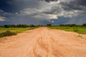 onverharde weg, bewolkte lucht en veld foto