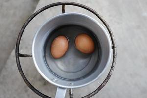 gekookte eieren in een pot op een gasfornuis foto