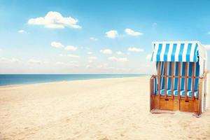 stormachtige Oostzee met strandstoelen en kustduinen. foto