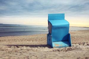 stormachtige Oostzee met strandstoelen en kustduinen. foto