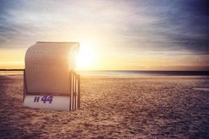 stormachtige Oostzee met strandstoelen en kustduinen. foto