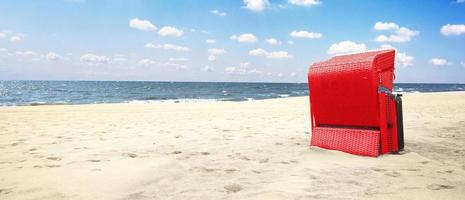 stormachtige Oostzee met strandstoelen en kustduinen. foto