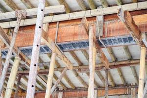 bamboe steigers ondersteunen betonnen balk op de bouwplaats van het huis foto